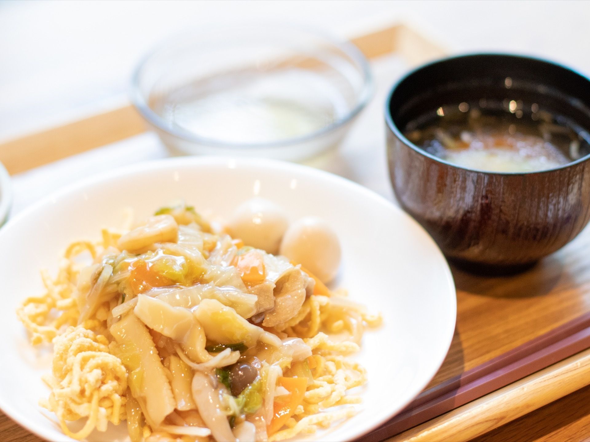 木のお盆に食事が置かれている。食材は小さめに切り、入居者様が食べやすいよう配慮している。食事は、主菜に汁物が添えられている。