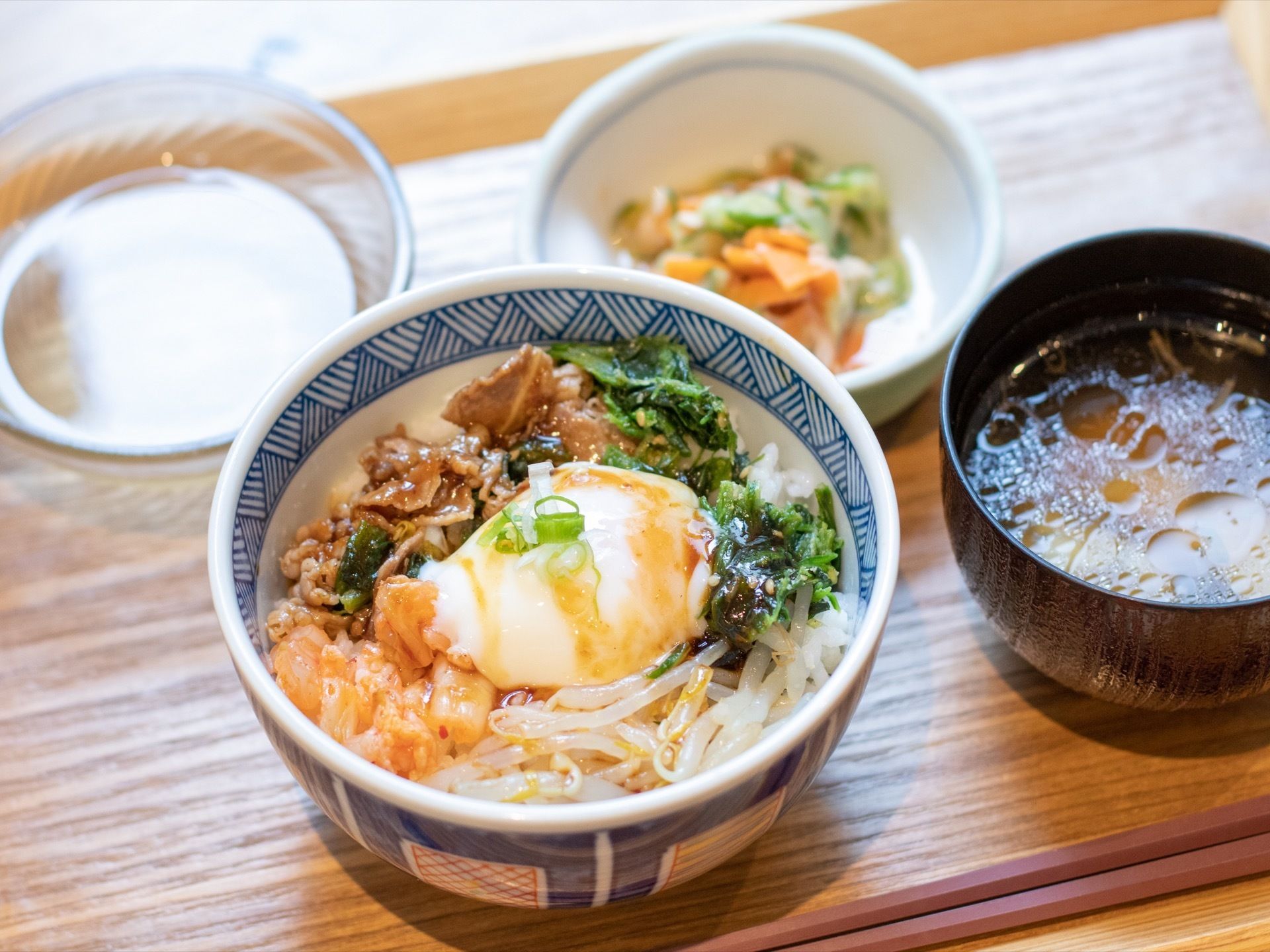 肉やもやし、葉物野菜が盛りつけられた丼に、温泉卵が添えられている。入居者様がお食事を楽しみにしていただけるよう、配慮されている。
