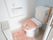 居室のトイレである。手洗いタンク付きの洋式便器が設置されている。壁には、Ｌ型手すりや呼び出しボタンが取りつけられている。