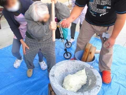 「きよみず苑・京都東」餅つき風景。お餅をつこうと奮闘する入居者様をサポートしているスタッフの様子です。