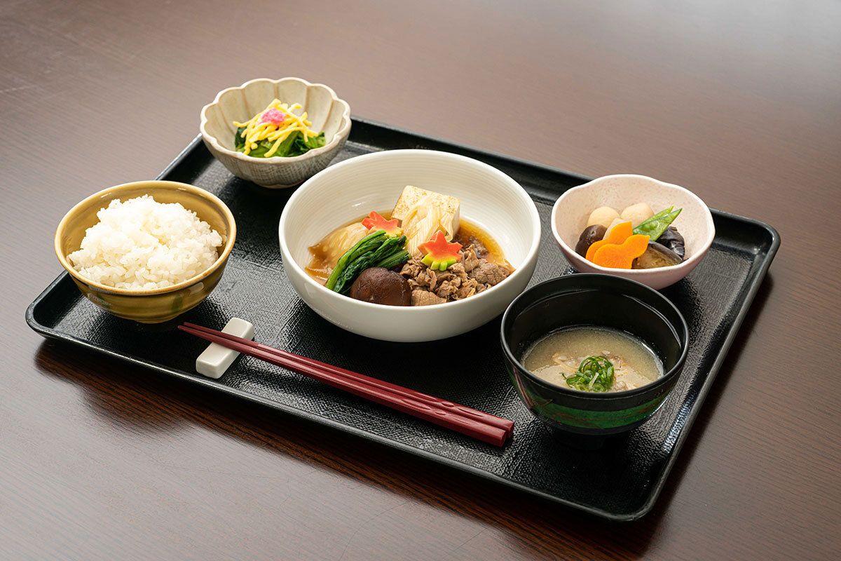 すき焼きとほうれん草のおひたしと野菜の煮物、ご飯と味噌汁の付いたメニュー