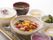 美しい器に盛り付けられた、ご飯に汁物、肉団子の甘酢あんかけ、茹で野菜、漬物にロールケーキと盛りだくさんの食事である。