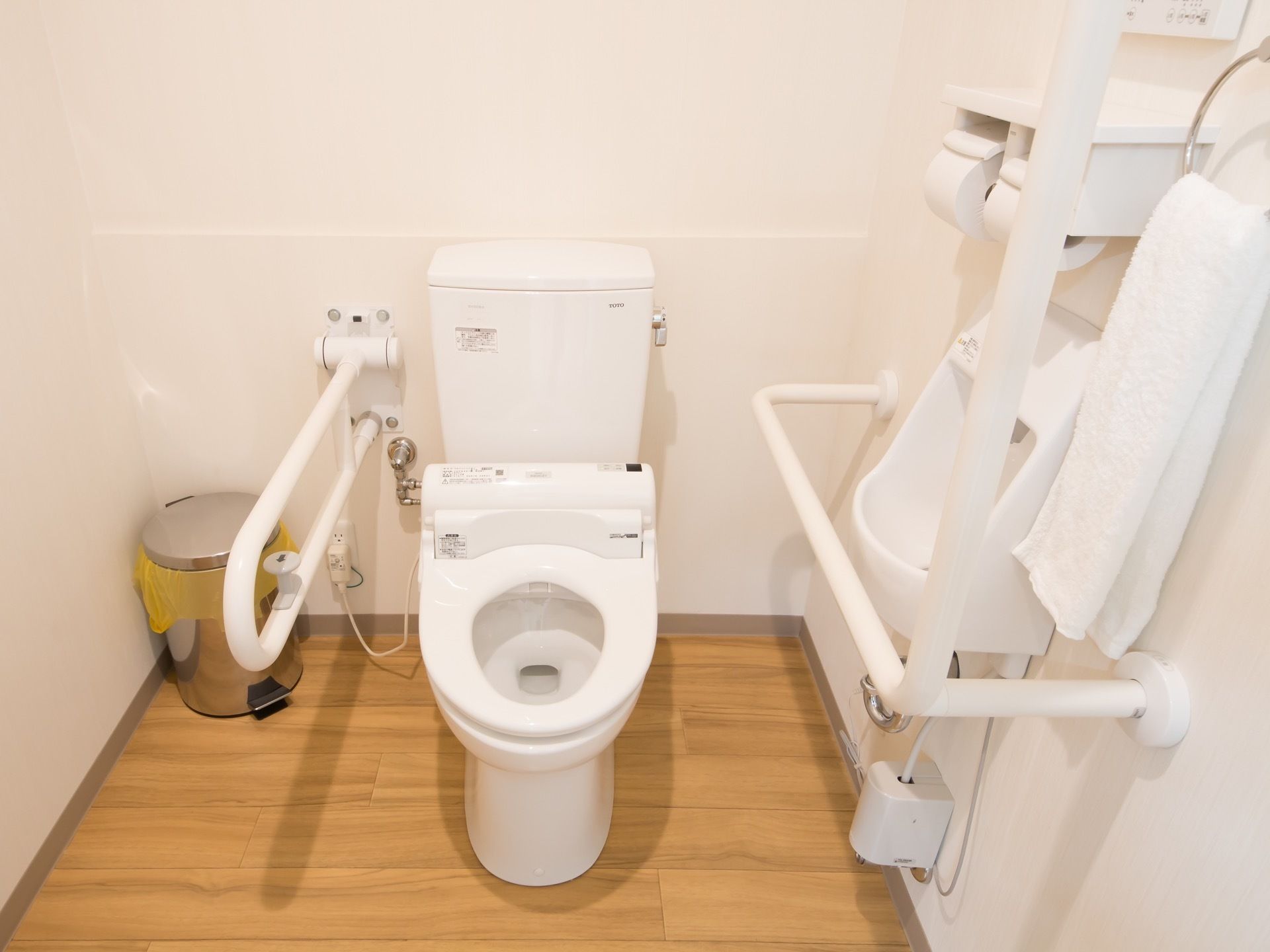 トイレは広く白い壁、木目調の床で清潔である。手すりのついた洋式便器の隣には、オストメイト対応トイレがある。