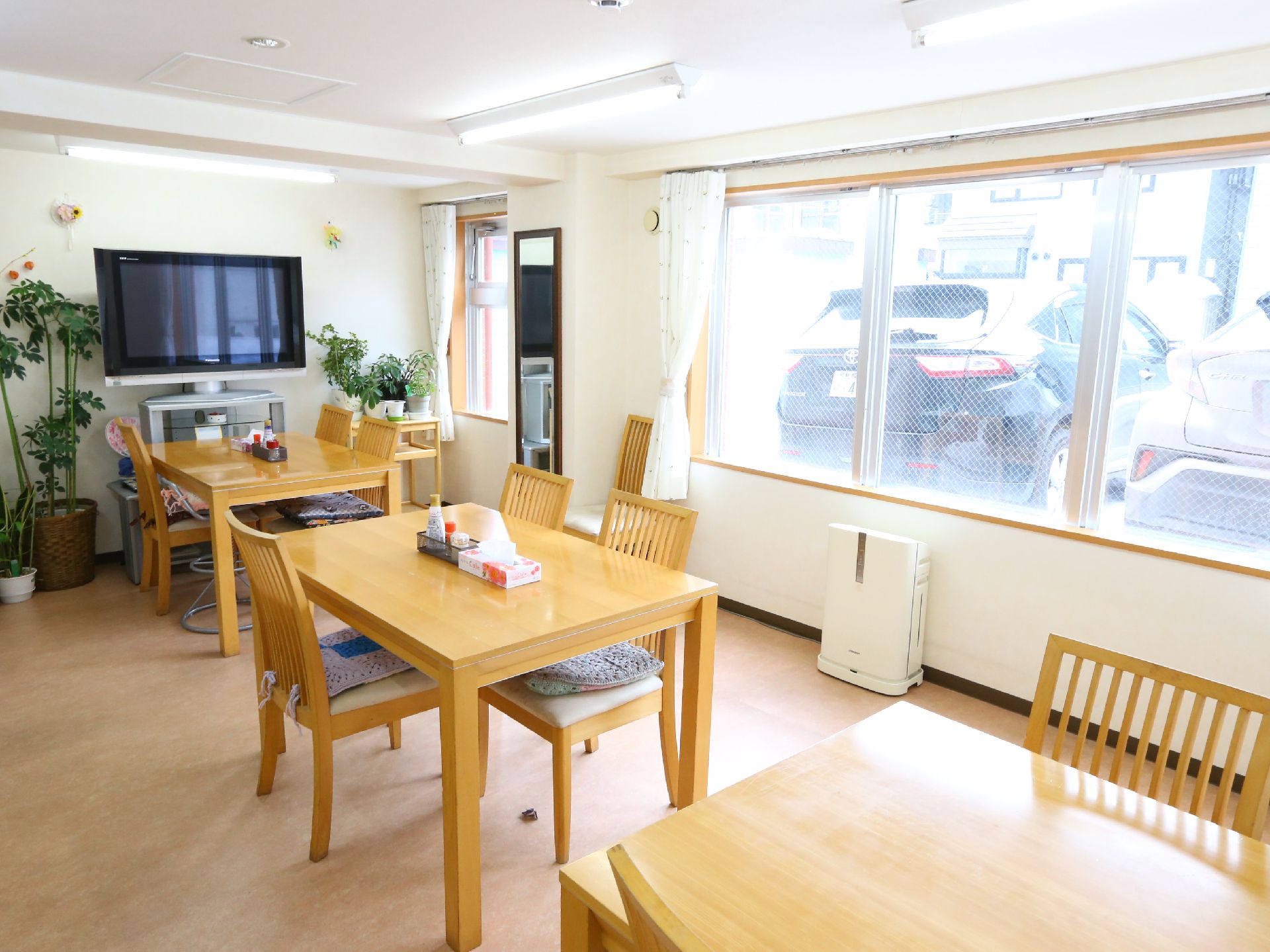 大きな窓からの採光でとても明るく、壁際にテレビが置かれている食堂