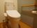 トイレの壁はツートーンカラー、床はフローリング仕様となっている。壁にはＬ字型の手すりが備わっており、立ち座りをサポートしてくれる。
