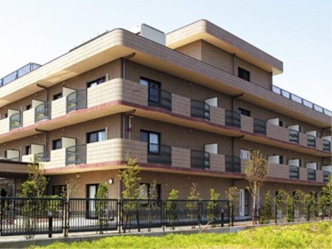 各居室のバルコニーに、アーチ状にせり出した柵が取り付けられている施設外観