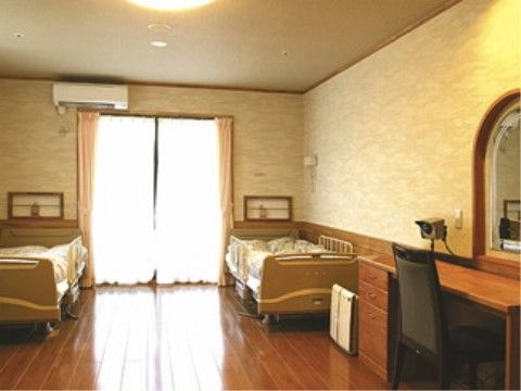 掃き出し窓の両側の壁際に、転落防止柵のついたベッドが２台置かれている居室