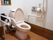 少しピンクがかったトイレである。左右に手すりがあるので、安心できる。ナースコールやウォシュレットのボタンが壁に設置してある。