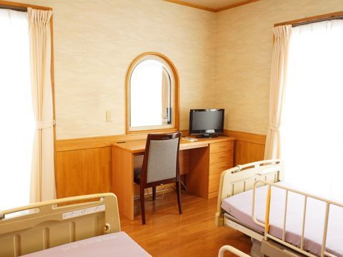 ふたつの窓から明るい光が差し込む二人用居室。ベッドにはいずれも、転落防止のための柵が設置されている。