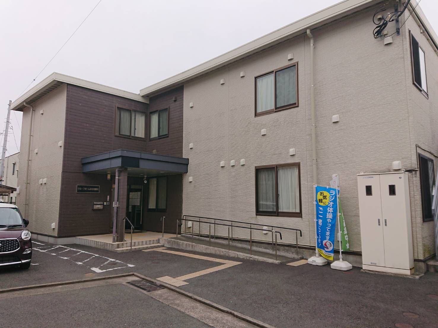 女性ケアマネジャーの話を笑顔で聞く高齢女性