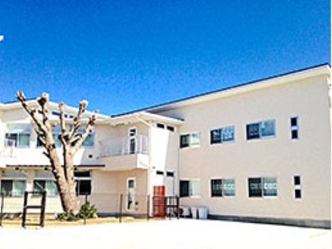 建物の前はコンクリート敷きの広い空間になっている。建物に隣接した場所にフェンスで囲まれた小さな庭がある。