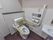 個室内に洋式トイレがあり、背もたれ付の手すりが取り付けられている。壁にはＬ字型の手すりとナースコールが設置されている。