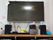 薄型テレビが壁に掛けられている。テレビの下にはスピーカーが2台あり、DVDプレイヤーも置かれている。