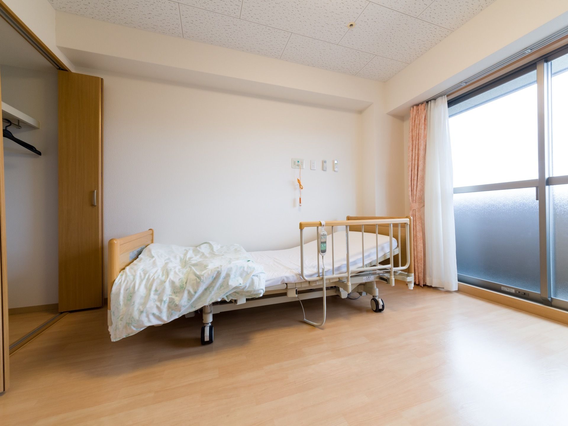 白色と白木の木目調の内装である。横面は大きなガラス戸があり、壁際に介護用ベッドを置いている。傍には収納庫を設置している。