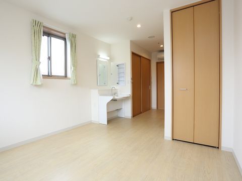 天井近くまでの高さの開き戸がついた収納スペースを備えた居室