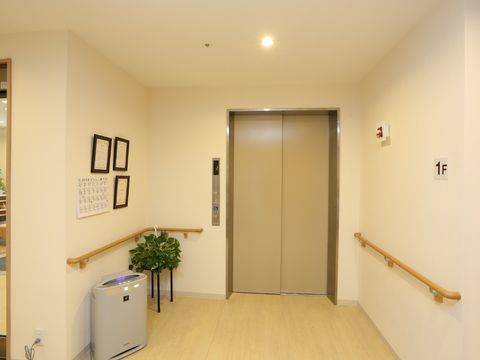 両側の壁に手すりが設置されている、エレベーターの乗降口付近