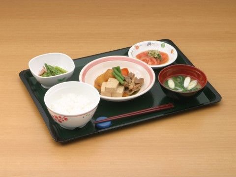 黒いお盆に載っている、健康に気を配った組み合わせのお食事