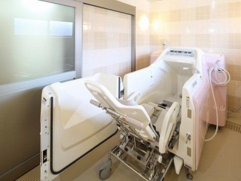 お体の不自由な方でも安全に湯船に浸かることができるように、専用の浴槽が用意されている。浴室のドアはすりガラスである。