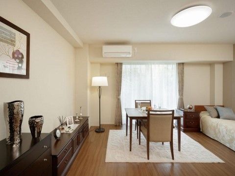 ベッドや棚、テーブルに２客の椅子、ランプなどが備え付けられた居室。花瓶や絵などのディスプレイも充実している。