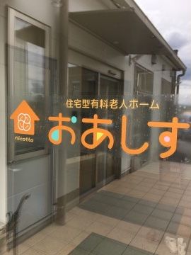 オレンジ色の文字で施設名称が書かれているガラスの扉