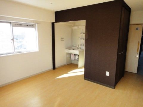 洗面台付近のスペースが濃い茶色の建具でおおわれている居室