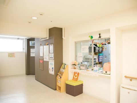 ピンク色の公衆電話がカウンターに置かれている受付窓口