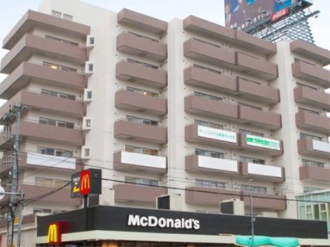近くにファストフード店がある場所に建つ、高層階の施設外観