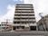 施設建物を正面から見たところ。１階部分の右側に出入り口があり、中には駐車場及び駐輪場が設けられている。