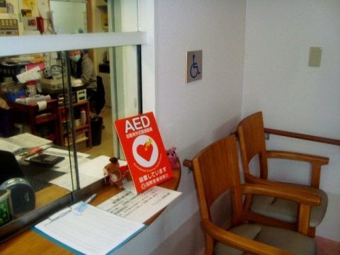 バインダーの横にAEDの看板が置かれている受付窓口