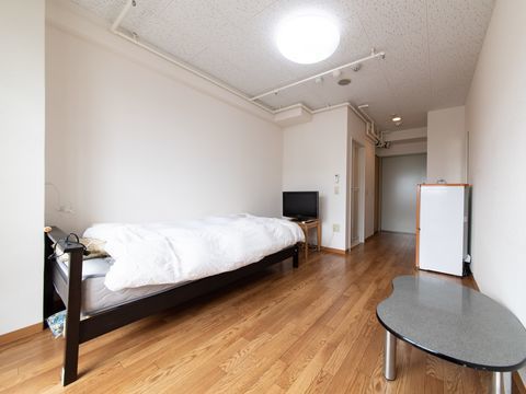 ベッドの足元の壁際にテレビが置かれている一人用の居室