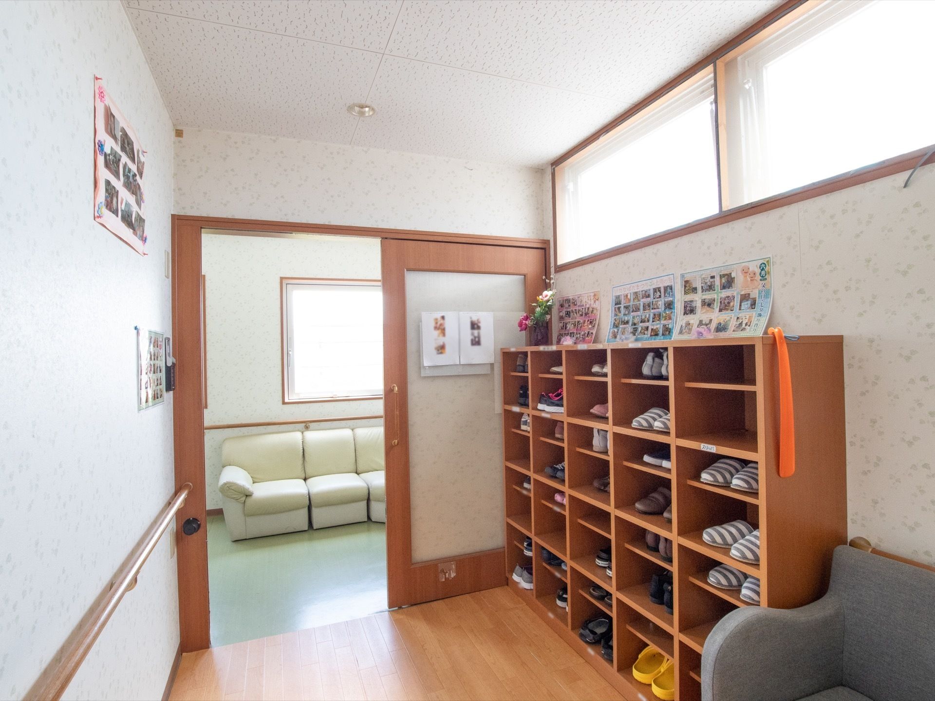 引き戸の向こう側には、白いソファーが置かれている。扉手前には靴箱が置かれ、外履きやスリッパなどが入っている。
