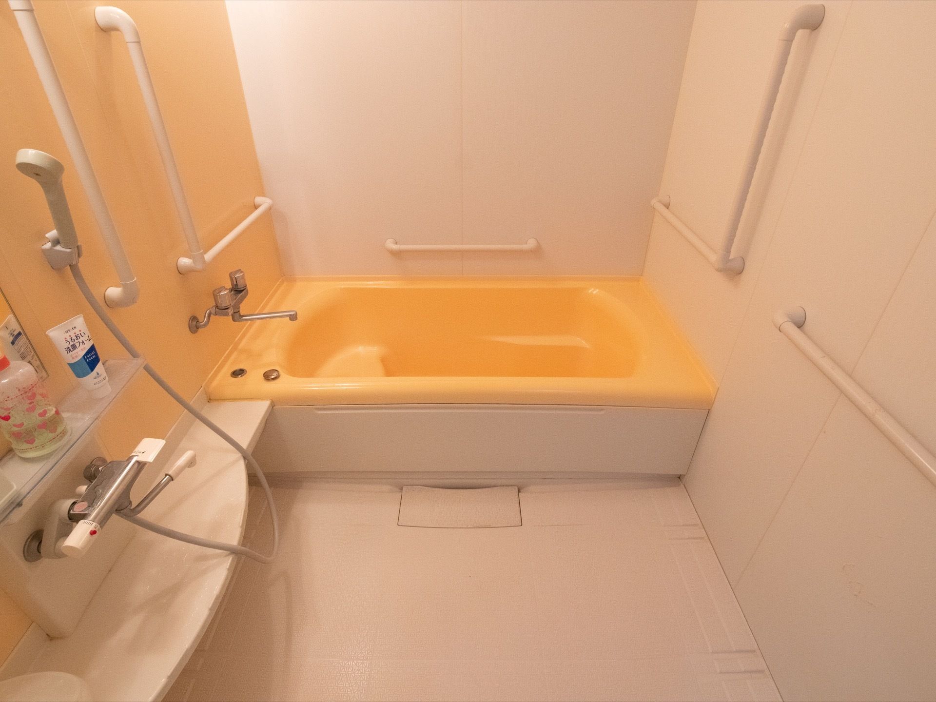 入居者様がご利用する浴室は浴槽とシャワーを備えている。壁面には転倒防止の手すりを設置して安全面に配慮している。