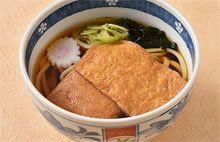 なると巻き、ねぎ、ワカメ、油揚げをトッピングした、きつねうどん