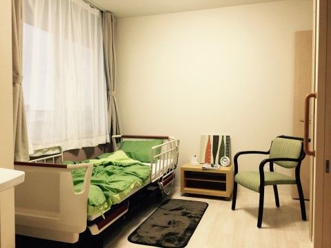窓際に介護用ベッドが置かれ、滑り止めマットが設置されている居室