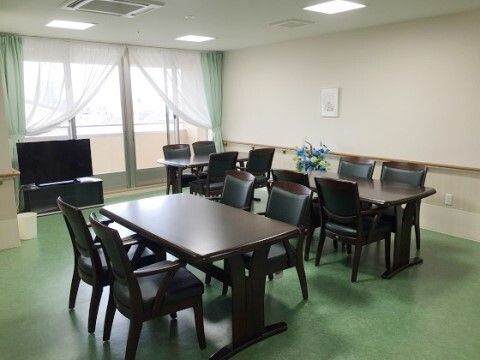 ベランダが完備され、掃き出し窓のそばにテレビが設置されている共有スペース