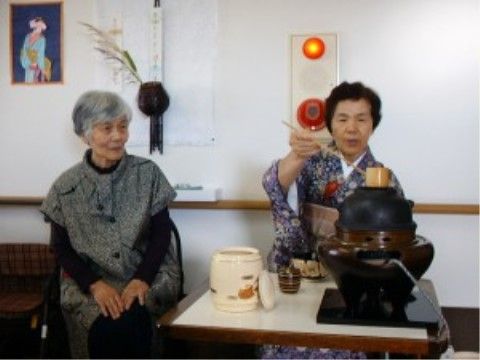訪問されたお茶の先生のお手並みに見入っている女性入居者様
