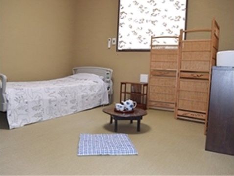 座布団の近くにあるちゃぶ台の上に急須と湯呑が置かれている和風の居室