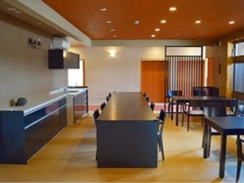 中央部に黒色の長テーブルが置かれている休憩スペース