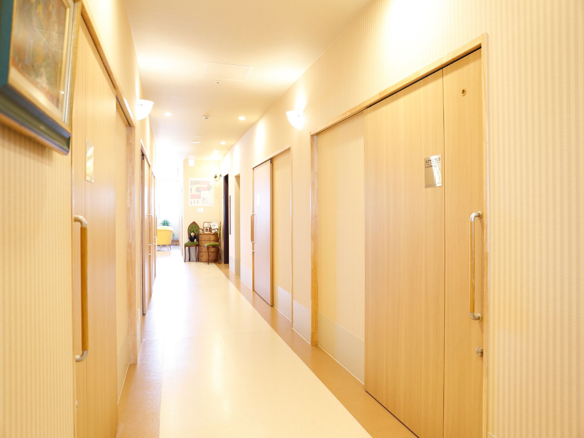 建物内の廊下は、照明で明るくなっている。部屋に入る扉が横開きで、取っ手が縦に付いているため、力の入らない方でも開け閉めが可能。