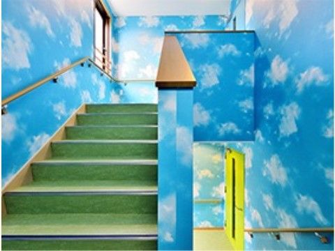 階段の両側や踊り場の壁に青空と雲が描かれている施設内部