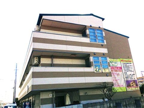 白とブラウン系の３階建ての建物である。建物の前正面には大きな垂れ幕が２枚かかっていて、施設の紹介が書かれている。
