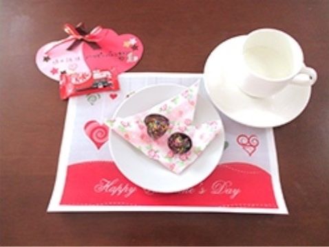 コーヒーカップの近くに置かれた、２月のイベントにちなんだお菓子