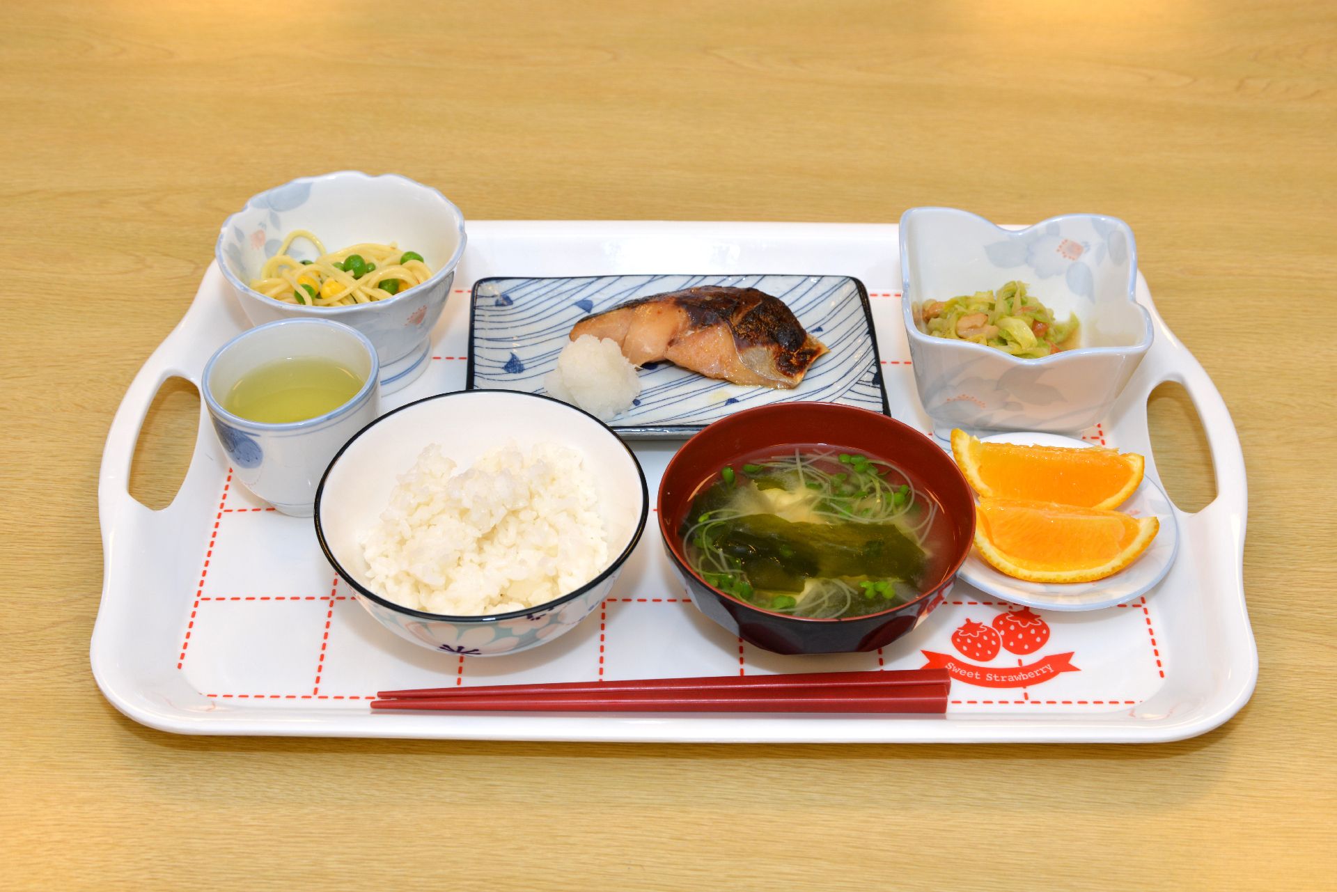 白地に赤色の点線が描かれたトレイに載っているお食事