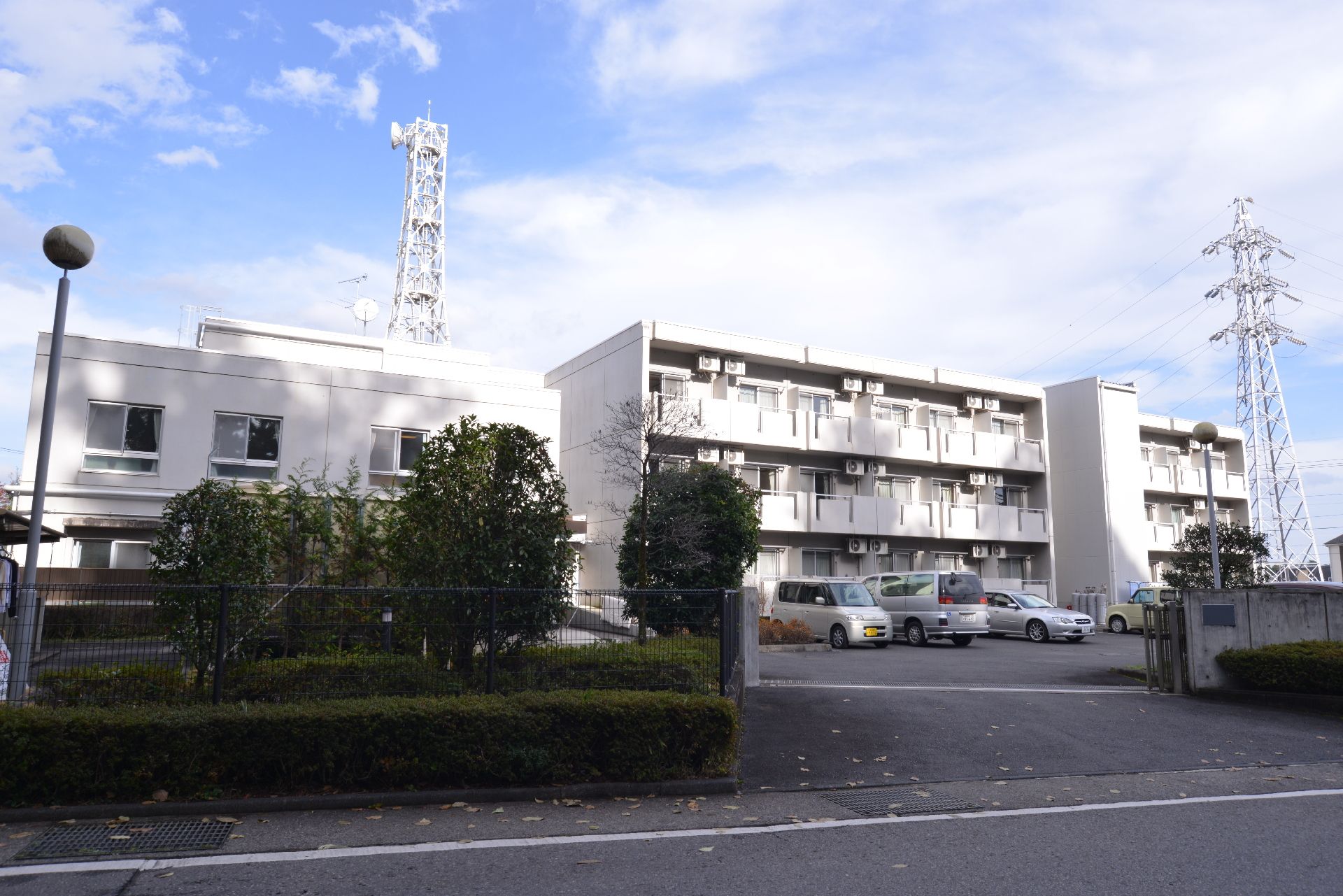 白色で統一された外壁を持つ、一部３階建ての施設外観