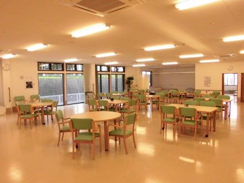 天井は高くエアコン、照明設備が設置されている。ガラス引き戸があり、広いスペースにはテーブルや椅子が置かれている。