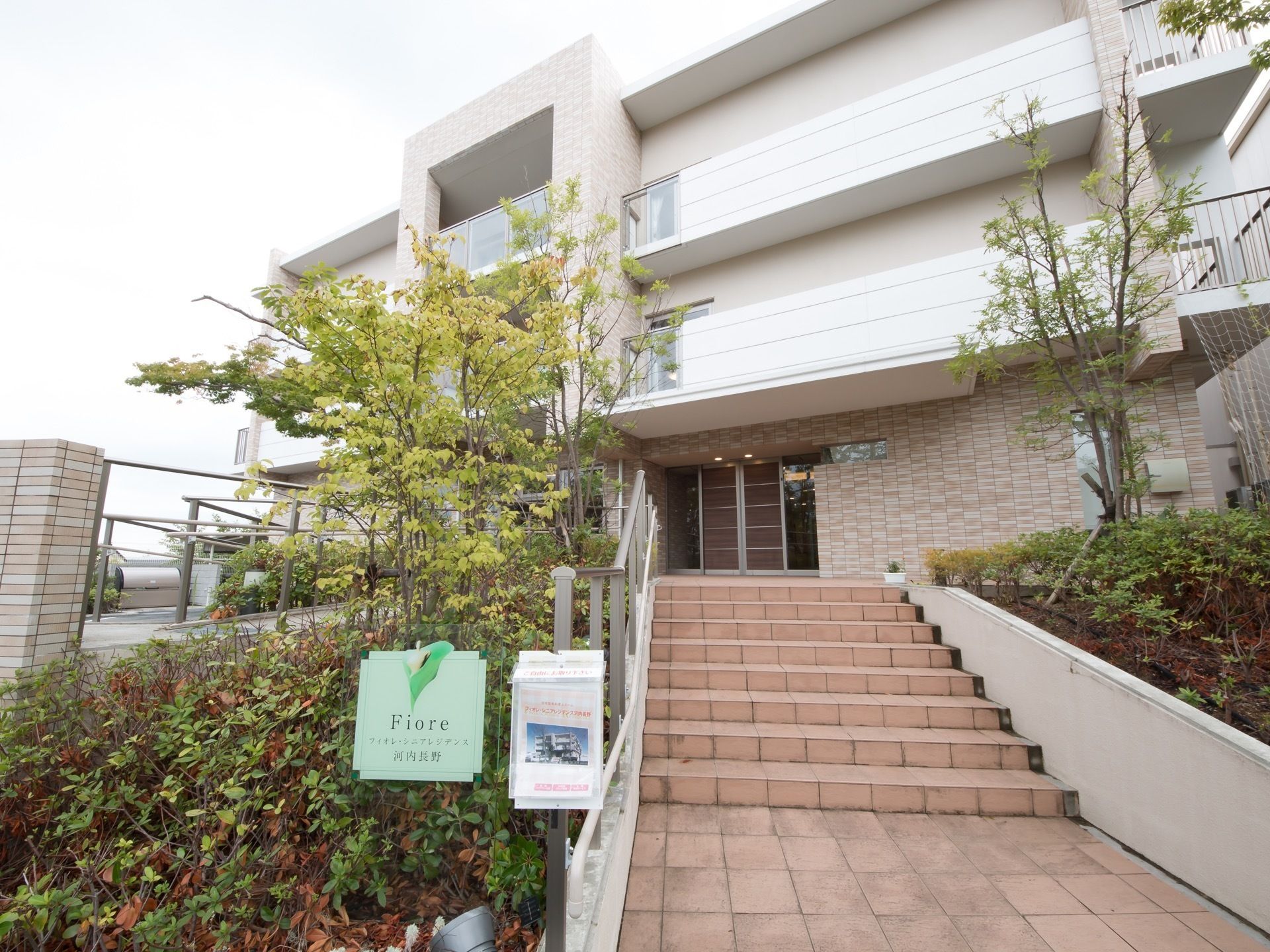 段差の低い階段が玄関まで続いており、安全のために片側には手すりが設置されている。レンガの敷かれた通り道が、穏やかな雰囲気を感じさせる。