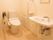 白を基調としたトイレは、掃除が行き届き清潔感がある。温水洗浄便座が設置されていて、壁には手すりも付いている。