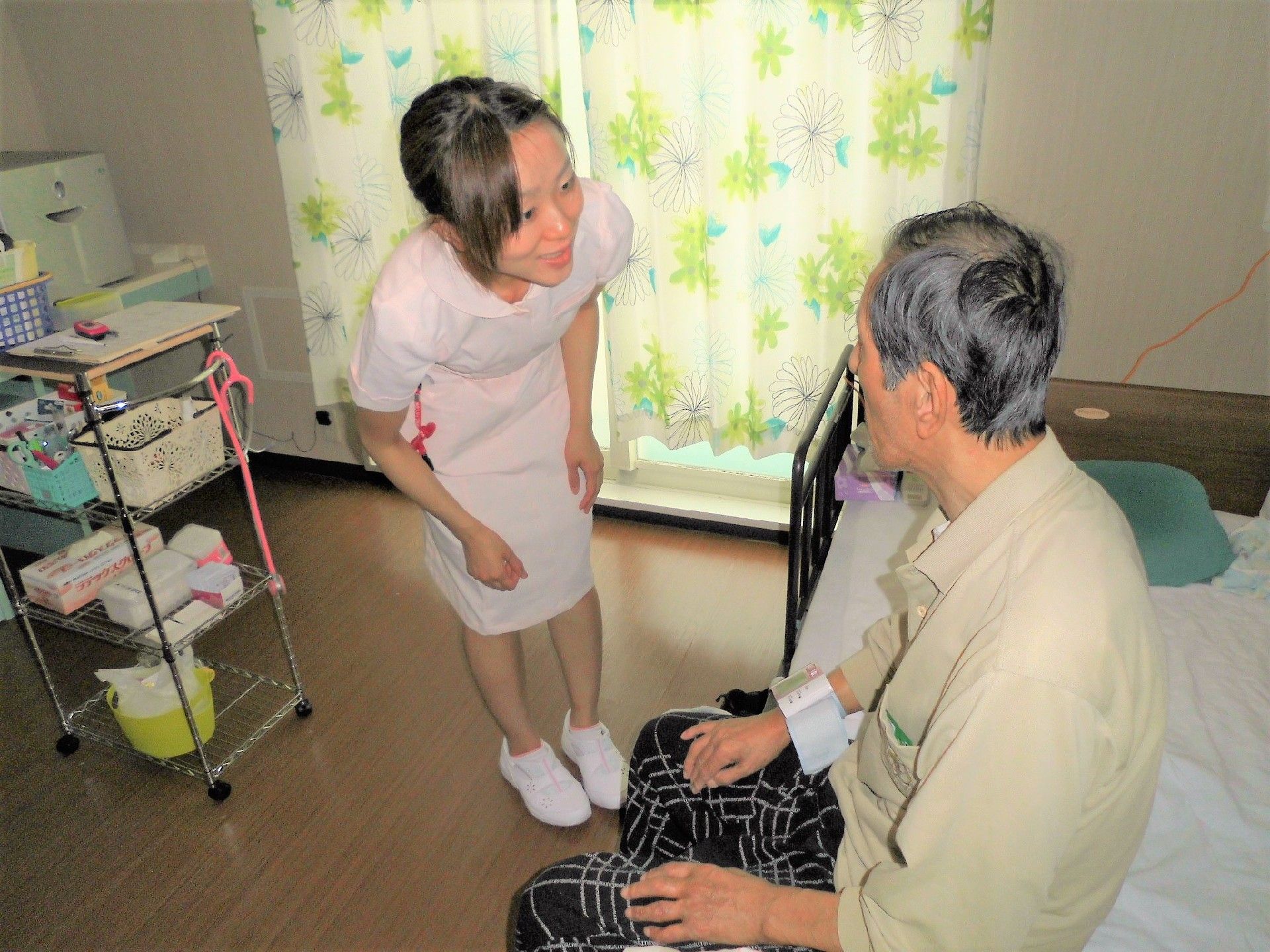 ワゴンにいろいろな物を載せて、入居者様の居室を訪問している女性スタッフ