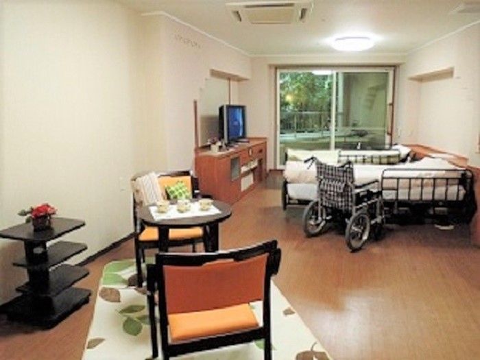 電動ベッドが二台並べて設置されている。丸いテーブルと椅子が二脚置かれており、ベッドの側には車椅子がある。