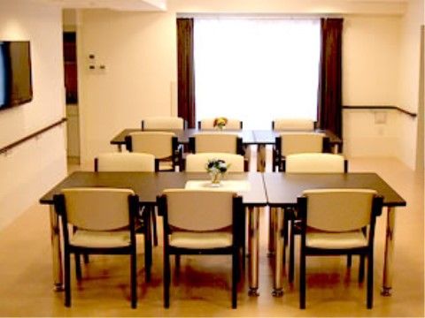 各テーブル席から鑑賞できる位置に壁掛けテレビが設置されている。壁には手すりが取り付けられている。卓上には花が飾られている。